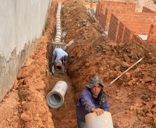 tubo de concreto sendo instalado em obra residencial para drenagem de aguas pluviais