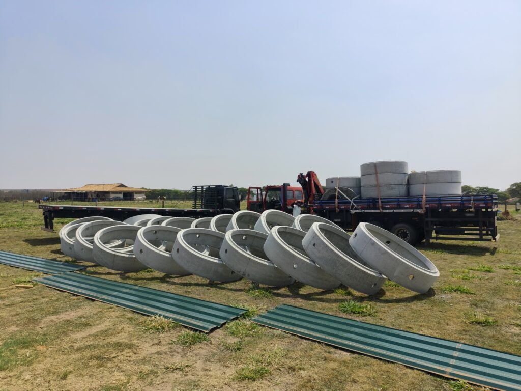 caminhões descarregando anéis de concreto