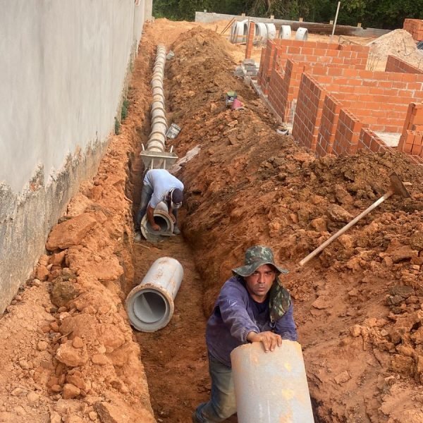 tubo de concreto sendo instalado em obra residencial para drenagem de aguas pluviais